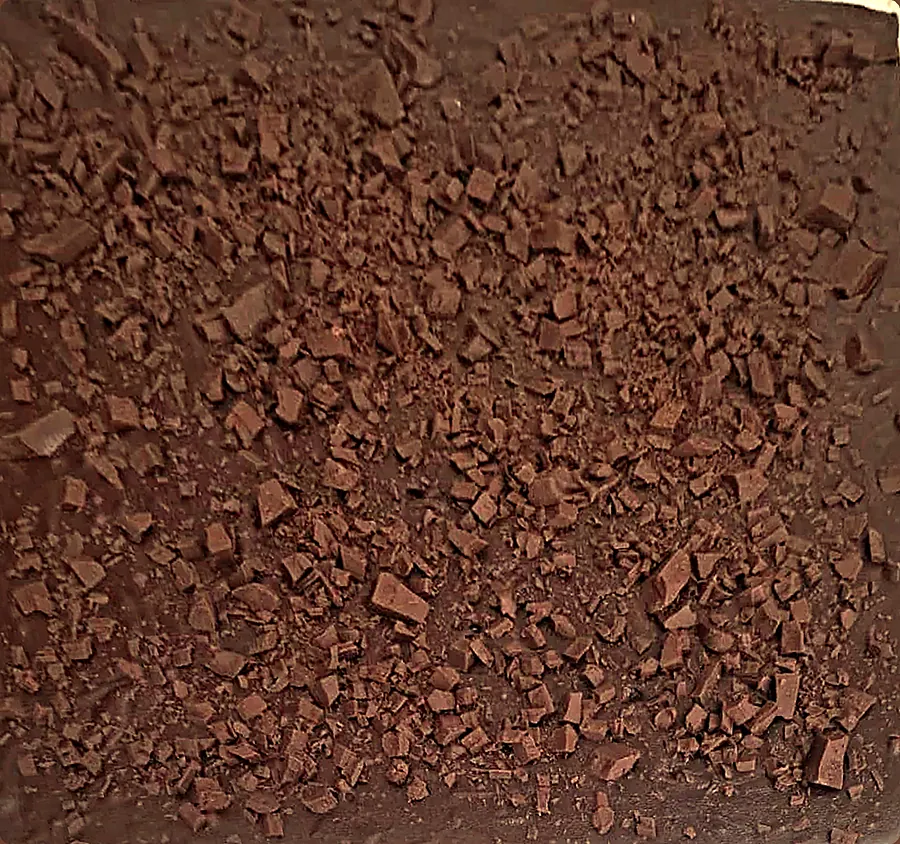 Uma fornada inteira da Dora, ainda sem cortar, coberta de lascas de chocolate