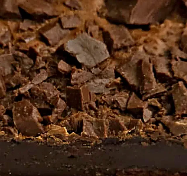 Brownie da Dora de perto: lascas de chocolate por cima e a base escura e cremosa